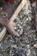 De hand van een kind dat werkt in de micamijnen van het dorp Ampikazo op Madagascar.