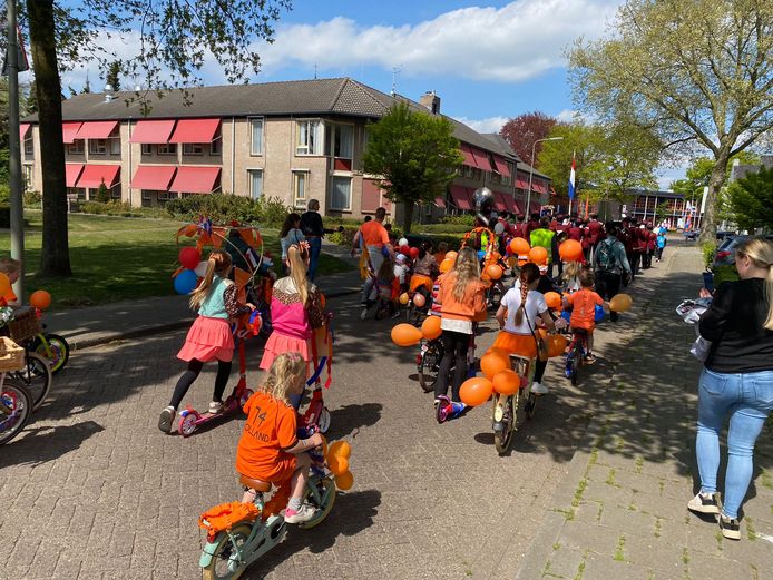 De versierde fietsoptocht ter hoogte van het bejaardenhuis. De bocht om stonden de (oud)-gedecoreerden langs de kant van de weg om te applaudiseren voor de deelnemers.