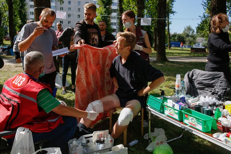 Artsen in Minsk behandelen buiten op straat vrijgelaten arrestanten, die in detentie door de politie zijn mishandeld. De Belarussische oproerpolitie pakte de afgelopen dagen duizenden betogers van de oppositie op.  Beeld EPA