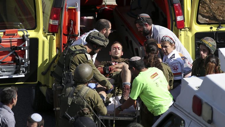 Een neergestoken Israëlische soldaat wordt met een ambulance naar het ziekenhuis gebracht. Beeld epa
