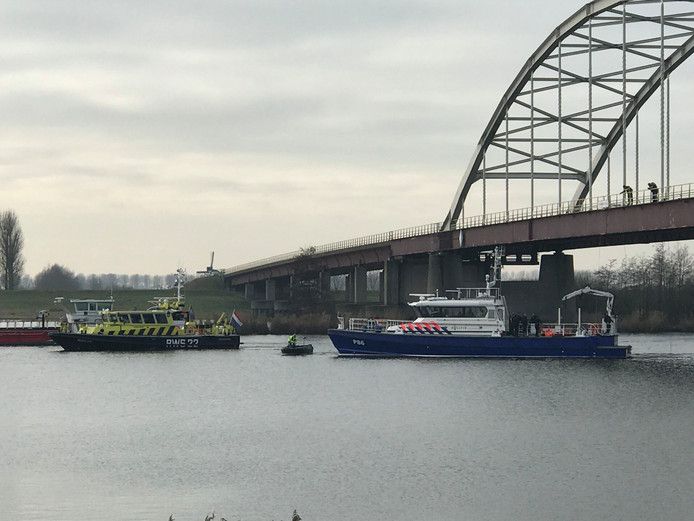 Politieduikers zoeken onder de brug bij Nieuw-Vossemeer naar de stoffelijke resten.