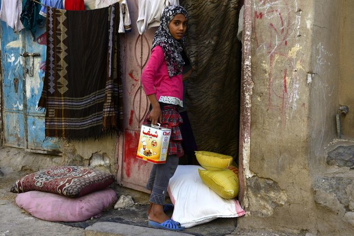 Een meisje ontvangt een voedselpakket van vrijwilligers in Jemen.