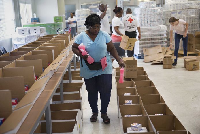 Vrijwilligers van het Rode Kruis op Curaçao vullen voedselpakketten, hygiënepakketten en pakketten met babyspullen. De pakketten worden uitgedeeld aan mensen die hun baan zijn kwijtgeraakt.