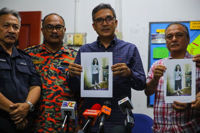 De politie met een foto van Nora Quoirin