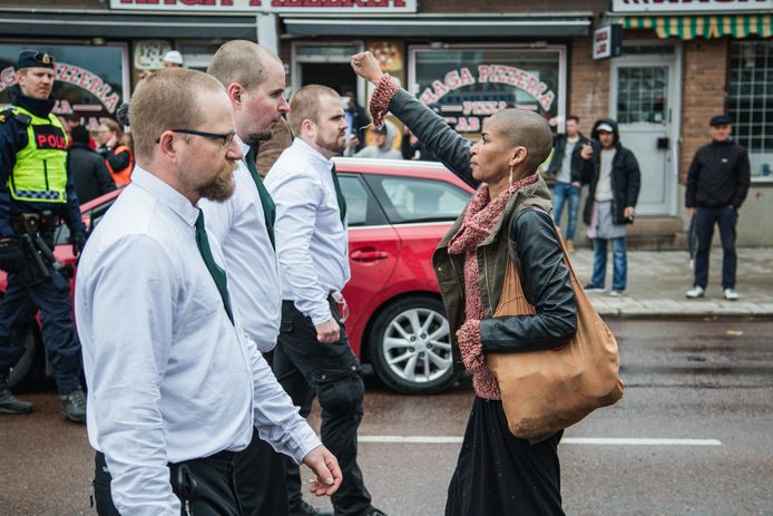 Een vrouw, met opgeheven vuist, keert zich tegen een demonstratie van de Nordiska Motståndsrörelsen (NMR) in Borlänge in 2015.