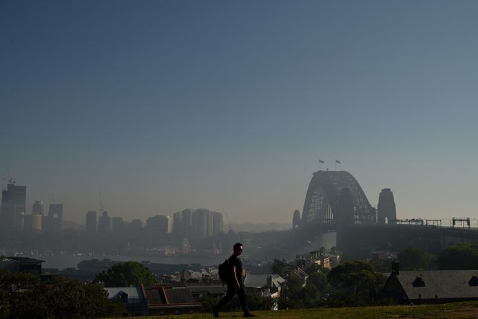 De Sydney Harbour Bridge met op de achtergrond de stad onder een deken van rook.