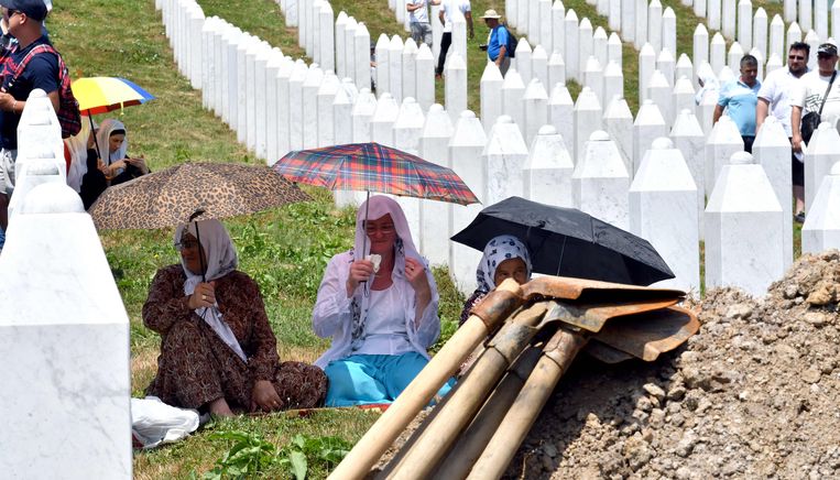 Bosnische moslimvrouwen en familie van de slachtoffers van Srebrenica wachten op de begraafplaats bij het stadje Potocari op de begrafenis van lichaamsdelen van mensen die in 1995 zijn vermoord.  
 Beeld AFP