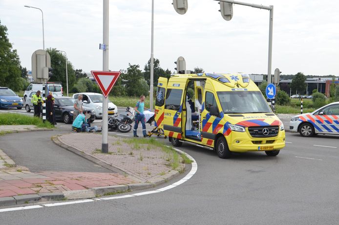 Hulpdiensten verlenen hulp aan de gewonde motorrijder.