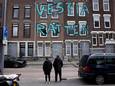 Bewoners staan voor een rij panden in de De La Reystraat in de Tweebosbuurt, die op het punt staan gesloopt te worden. Onbekenden spoten er vorige maand als protest deze graffiti op, die Vestia een dag later liet verwijderen.