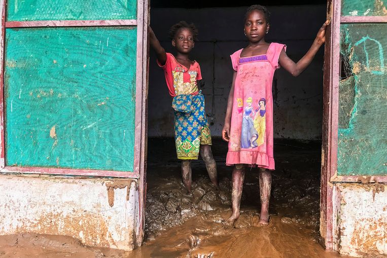 Kinderen staan in de deuropening van hun met modder besmeurde huis in de plaats Tete in Mozambique na het passeren van de tropische storm Ana. Beeld EPA