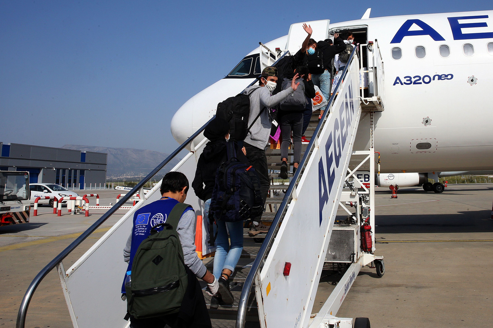 Minderjarige asielzoekers gaan het vliegtuig in onderweg naar Luxemburg.  Beeld AFP