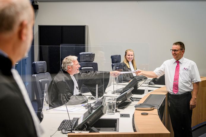 Bode Bert Keukenkamp overhandigt papieren aan politierechter Erik Berg. Op de voorgrond  officier van justitie Achilles Damen,  Sharon Jentzsch is griffier.