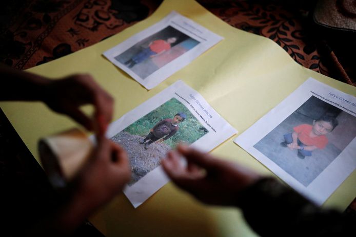 Familieleden plakken foto's van Felipe op een stuk gekleurd karton als eerbetoon aan het ventje dat stierf op zijn tocht naar Amerika.