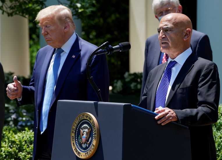 Moncef Slaoui, in mei aangesteld als hoofd van ‘Operatie Warp Speed’, doet in de rozen­tuin van het Witte Huis zijn vaccinbeleid uit de doeken. President Trump hoort dat het goed is. Beeld REUTERS