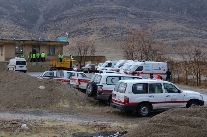 Ambulances en wagens van reddingswerkers staan klaar in de buurt van waar het vliegtuig gecrasht zou zijn.
