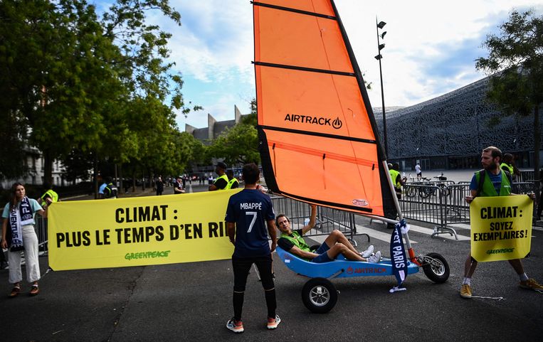 Activisten van Greenpeace klagen de klimaathouding van topclub PSG aan voor het Parc des Princes in Parijs. Beeld AFP