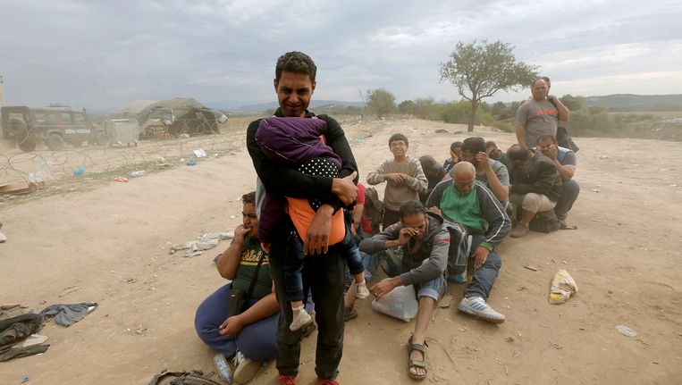 Syrische vluchtelingen wachten bij het Griekse plaatsje Idomeni. Beeld reuters