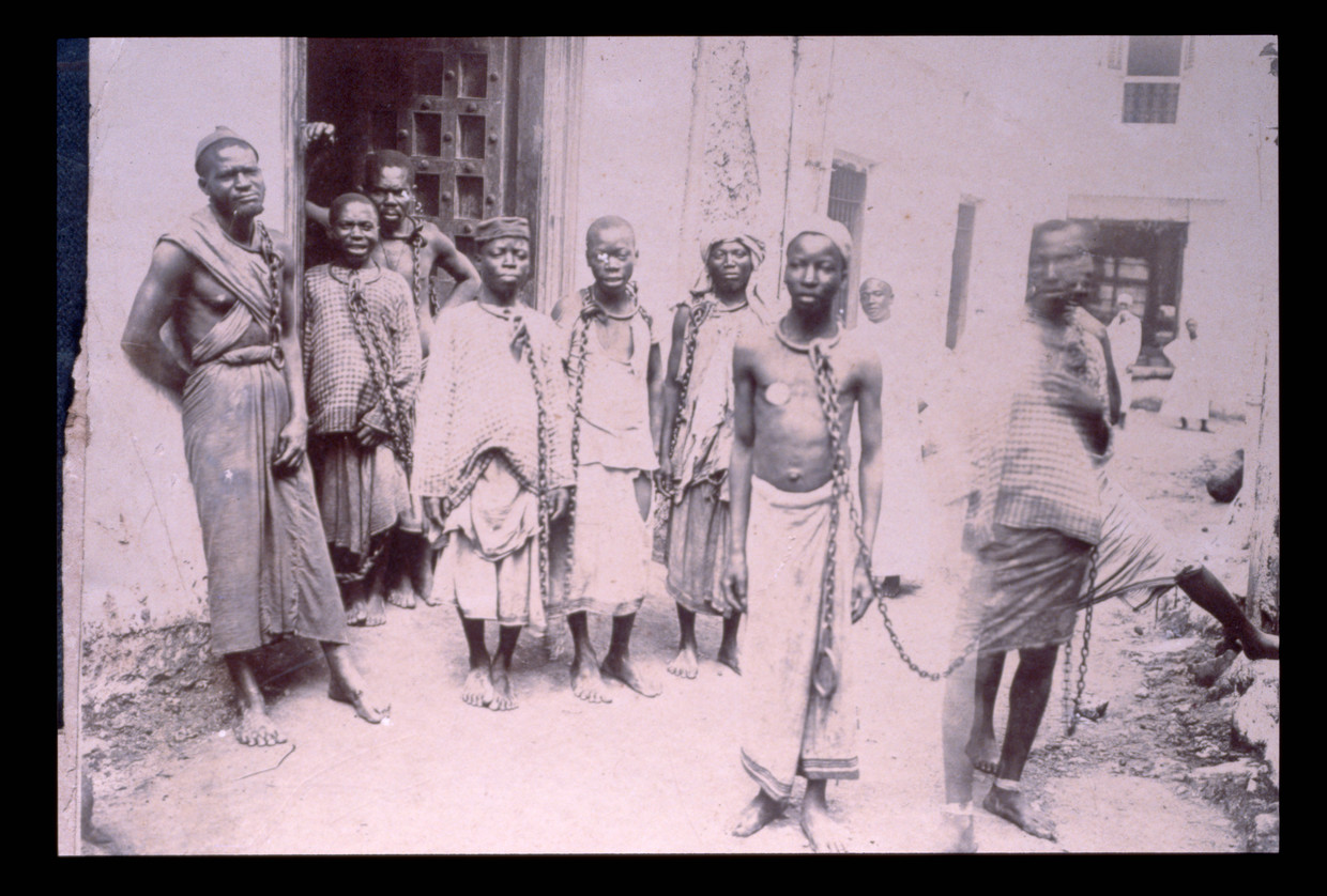 Geketende tot slaaf gemaakten op Zanzibar, 19de eeuw.  Beeld Corbis via Getty Images