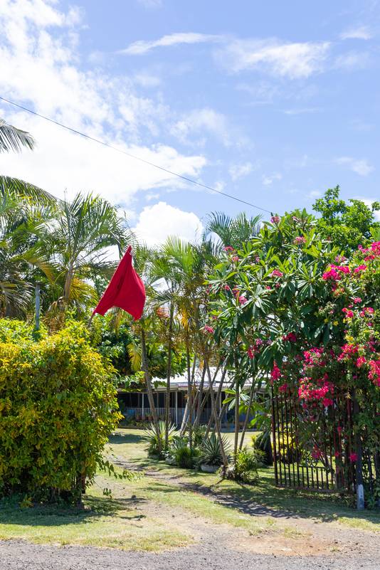 Een rode vlag bij een huis van Apia.