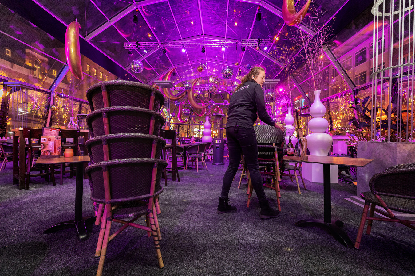 Lieke van de Meulengraaf verwijdert zaterdagavond na sluitingstijd enkele stoelen uit de tent van grand-café Centraal op de Markt in Eindhoven. De inrichting moest overal aangepast om te voldoen aan de 1,5 meterregel.