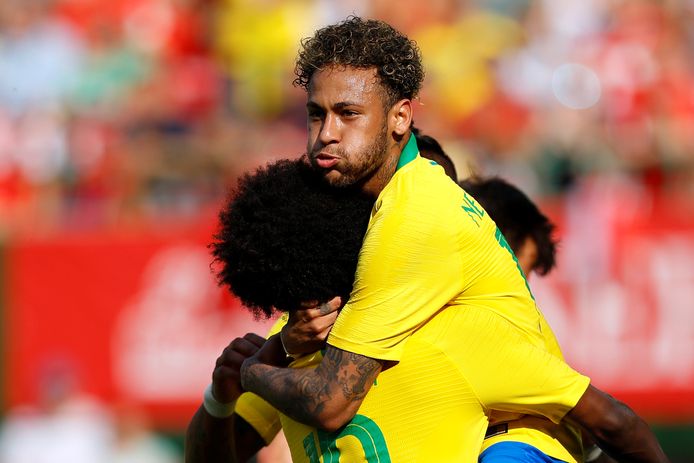 Neymar springt in de armen van Willian, nadat hij  Brazilië op 0-2 heeft gezet tegen Oostenrijk.