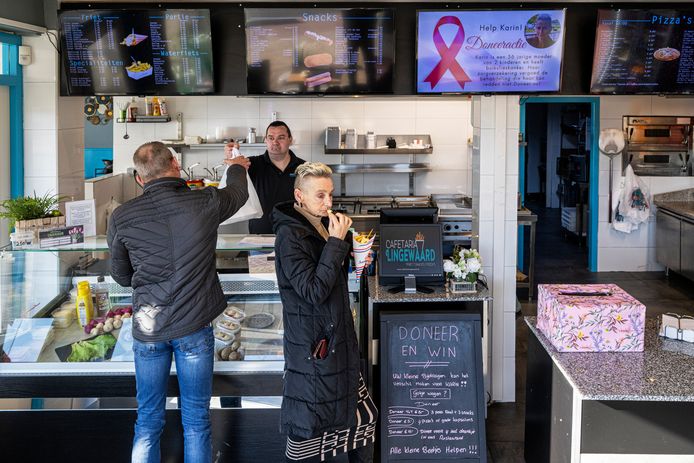 Cafetaria de Lingewaard is een doneeractie gestart om de operatie van Karin Grave te kunnen betalen. Cafetariahouder Danny Briese helpt een klant, terwijl Karin een frietje eet.