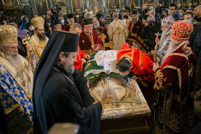 Servisch-Orthodoxe geestelijken betuigen de laatste eer aan de aan corona overleden patriarch Irinej in Belgrado.
