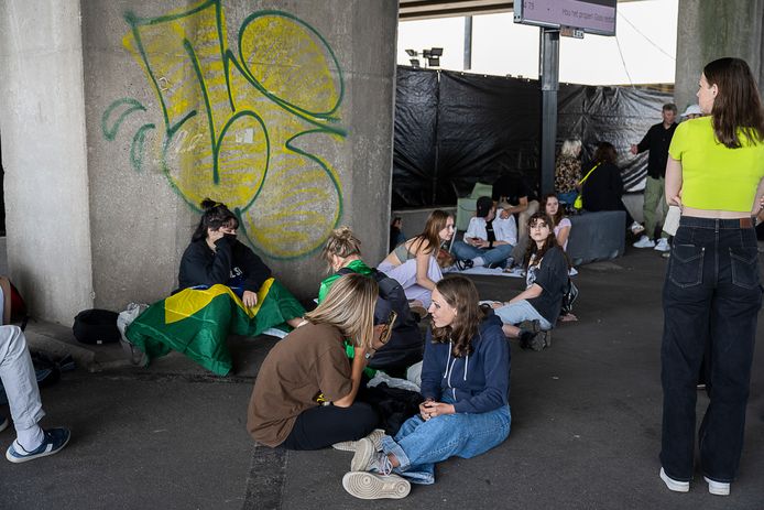 Ook mensen met zitplaatsen wachten enkele uren voor de aanvang van het concert op de koude stenen aan de ingang van het Sportpaleis.