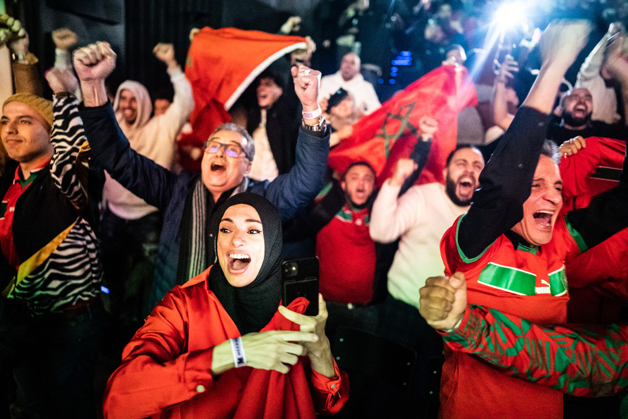 Mensen kijken de wedstrijd van Marokko tegen Spanje in de Meervaart in Osdorp. Beeld Joris van Gennip