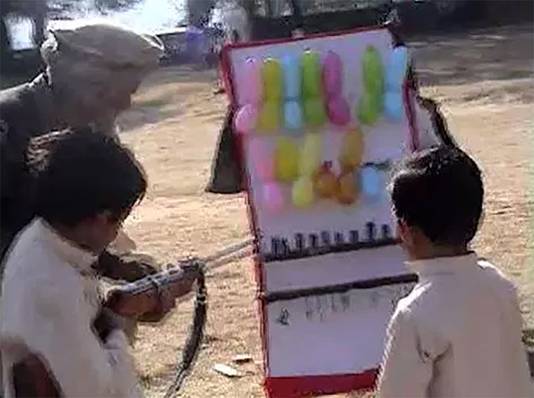 De kinderen van Osama bin Laden leren met geweren op balonnen schieten.