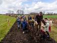 Scholieren van basisschool Servatius uit Borkel en Schaft helpen onder leiding van Arnoud Heijke van Wildbeheer Zuid Oost Kempen bij de aanleg van een vlechtheg aan de rand van het dorp.