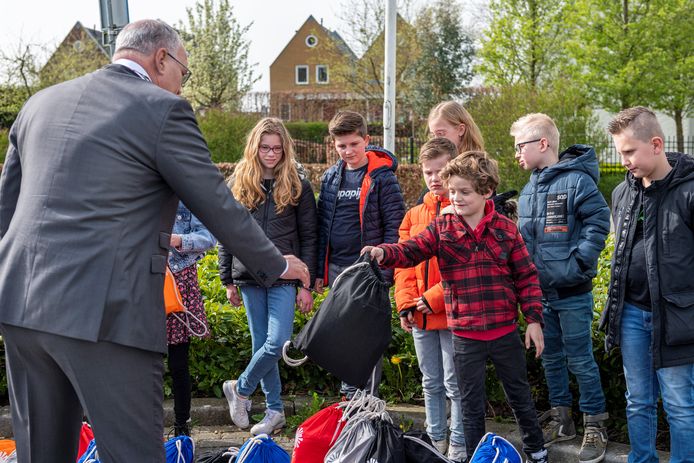 Tom ('bijna 7') overhandigt een tasje aan de Maasdrielse burgemeester Henny van Kooten