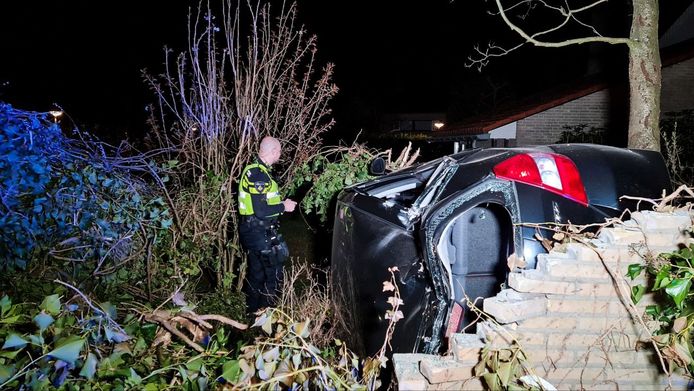 De auto in de tuin na een crash in Enschede aan de Noord Esmarkerrondweg. Twee personen raakten gewond.
