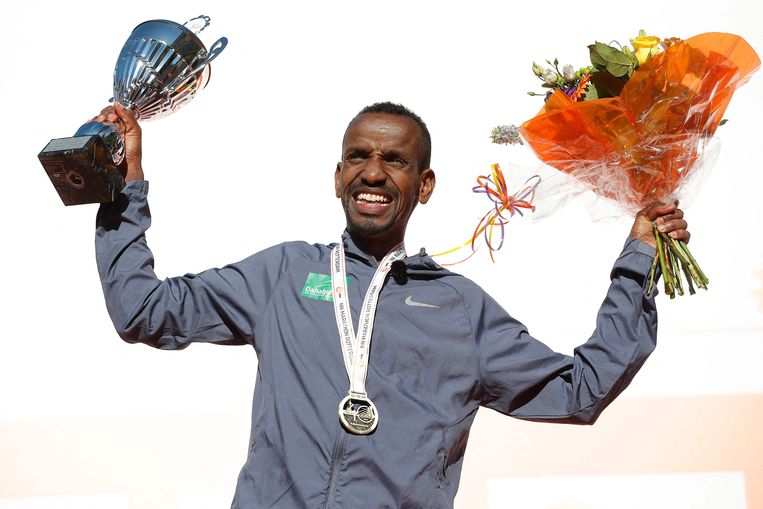Bashir Abdi pronkt met zijn trofee op het podium. Beeld AFP