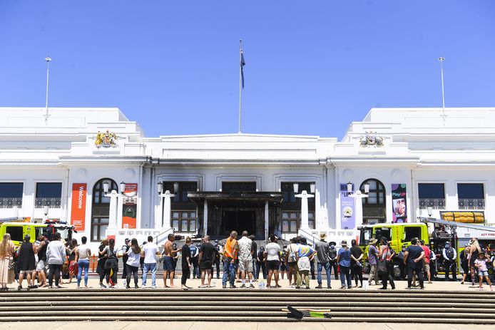 Protestanten staan voor de beschadigde ingang van het oude parlementsgebouw in Canberra.