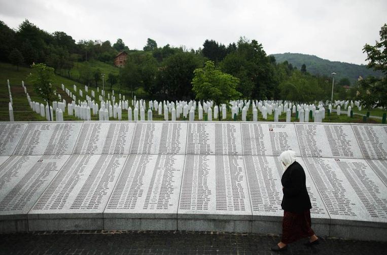 Een vrouw bij een monument waarop de namen van de duizenden slachtoffers van Srebrenica staan. Beeld reuters