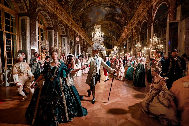 Gasten in barokkostuums schuifelen door de Spiegelzaal van het paleis van Versailles voor de vierde editie van de Fêtes Galantes. Beeld AFP
