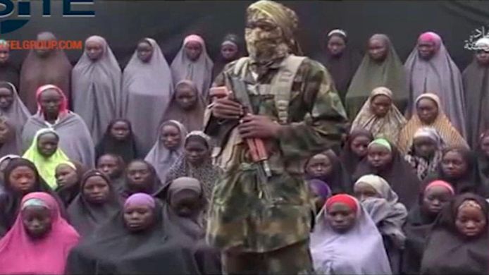 Een beeldfragment van een video uit 2016. Een soldaat van Boko Haram staat bij ontvoerde Chibok-meisjes. Boko Haram ontvoerde in april 2014 276 schoolmeisjes tussen 12 en 17 jaar uit hun school. Sindsdien hebben 107 meisjes de vrijheid hervonden.