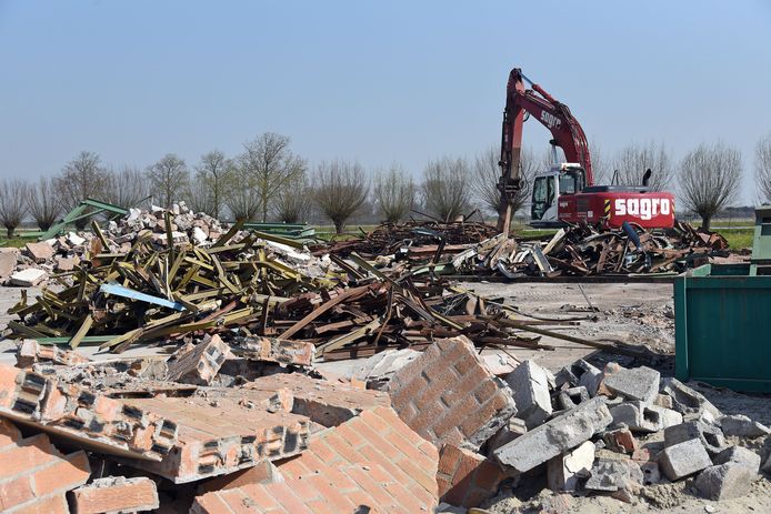 Een kraan is bezig met het scheiden van het sloopafval nadat het gebouw van Weemaes gesloopt is.
