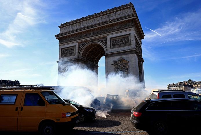 Franse automobilisten sturen hun auto's door traangas afgevuurd door Franse oproerpolitieagenten in Place Charles De Gaulle (Place de l'Etoile) a Parijs.
