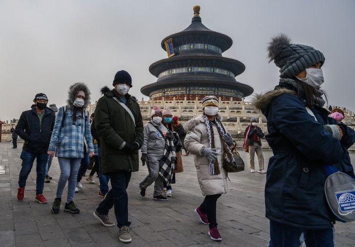 Toeristen dragen mondmaskertjes aan de Tempel van de Hemel in Peking.