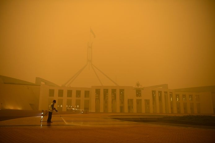 Het parlementsgebouw in Canberra is gehuld in oranje smog.