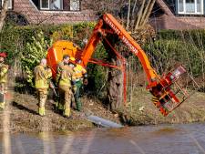 Werklift kantelt in Oosterhout, snoeiende man komt boven vijver te hangen en wordt uit voertuig bevrijd