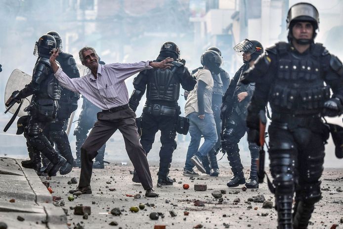 Een oudere man gooit te midden van Colombiaanse politieagenten stenen tijdens een campagnebijeenkomst van Rodrigo Londono Echeverri, de presidentskandidaat van de nieuwe partij van de voormalige FARC rebellen. Foto Luis Robayo