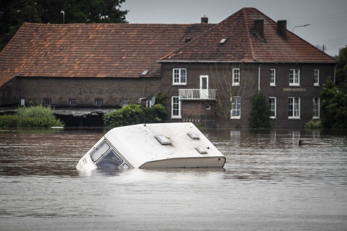 Een caravan drijft voorbij in het hoge water van de Maas in Roermond. Dit weekend komt het hoge water aan in Brabant.