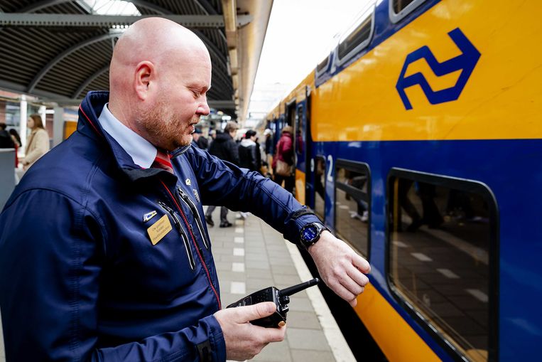 Een NS-conducteur met een smartwatch, sinds 2019 in gebruik om treinen op de seconde nauwkeurig te laten vertrekken. Tussen Amsterdam en Schiphol moet het nóg sneller, stelt de NS-directie. Beeld ANP