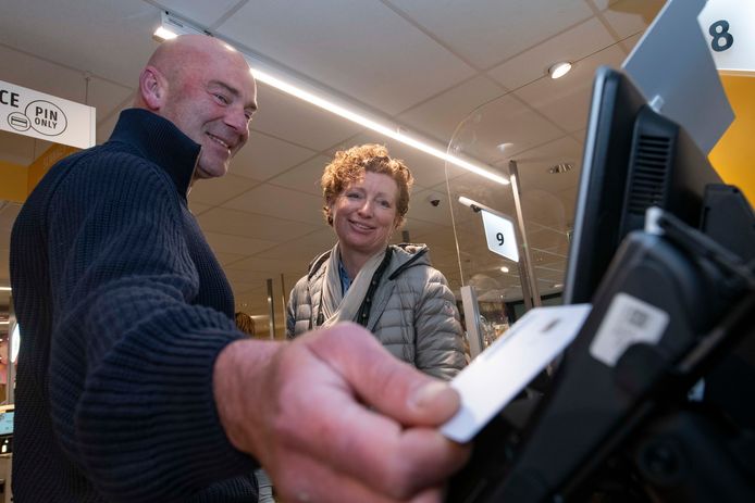 Martijn Tabbernee van Buyproxy test de betaalpas samen met wethouder Gerria Toeter bij de supermarkt in Raalte.