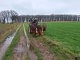 Met behulp van een trekker worden hagen geplant tussen Groesbeek en Wyler.