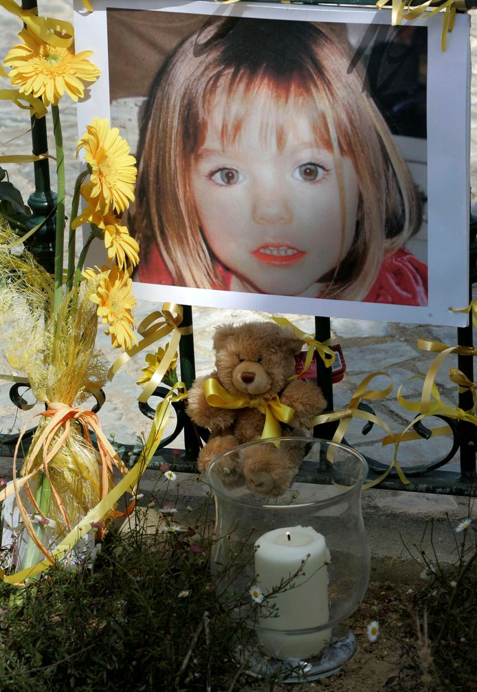 Bloemen, kaarsjes en knuffels bij een foto van Maddie McCann, in mei 2007 in Praia da Luz.