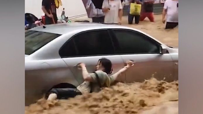 Une femme lutte pour sa vie au milieu des inondations.